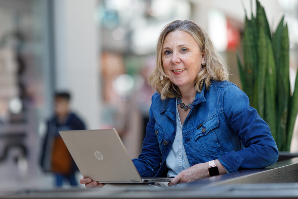 Nicole Bender sitzt mit einem Laptop im Forum Duisburg