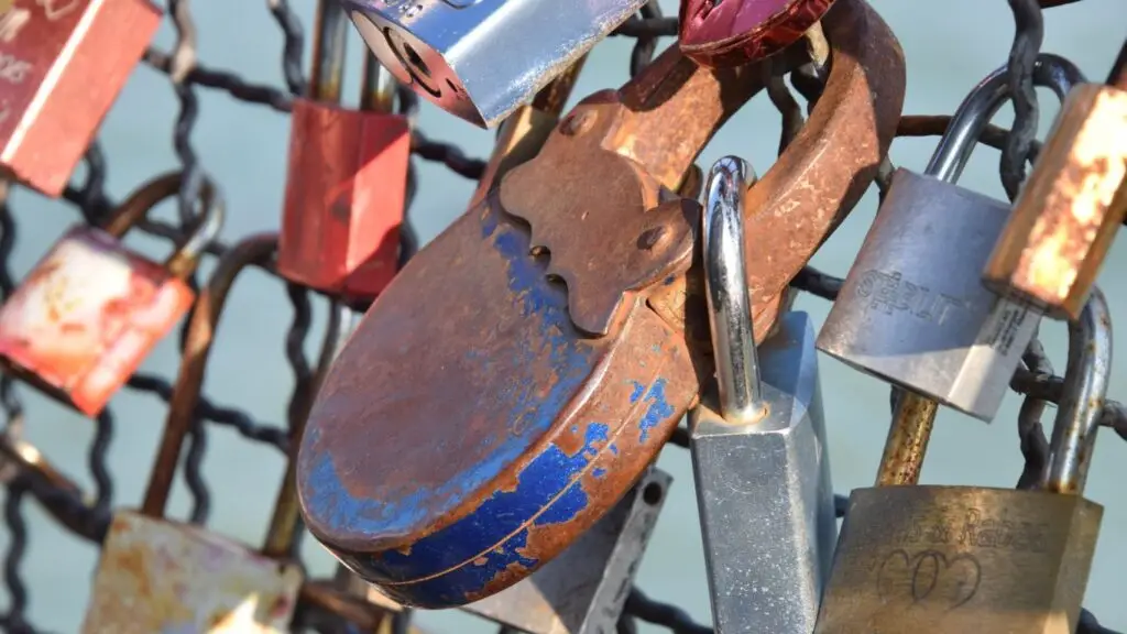 Schlösser hängen an der Absperrung an einer Brücke bildlich als Signal für Datenschutz