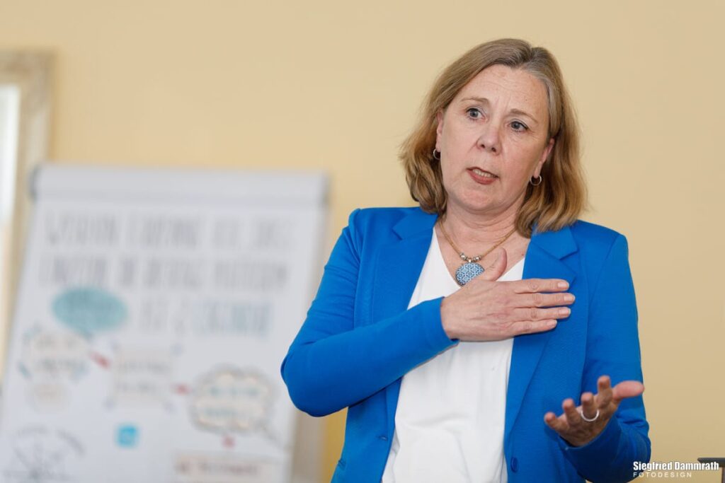 Blonde Frau präsentiert an einem Flipchart