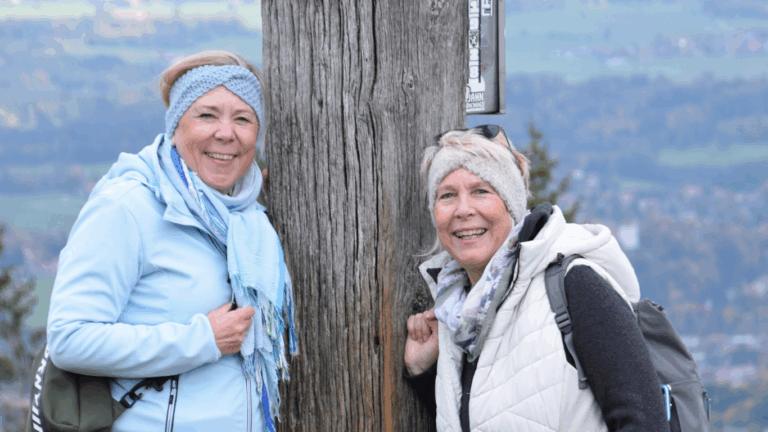 Frauen mit Stirnband am Gipfelkreuz des Blombergs in Bad Tölz