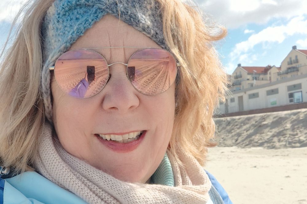 Autorin des Blogartikels mit Sonnenbrille am Strand.